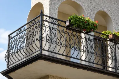 Kuta balustrada balkonowa z klasycznym ornamentem zwojowym, model BKZ15 — odtworzone ujęcie oryginalne. Wizualizacja AI.
